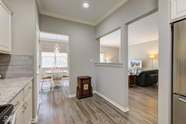 13879 Meadow Grass Way, Fishers, IN 46038 - kitchen with stainless steel appliances, wood finished floors, white cabinets, crown molding, and light stone countertops