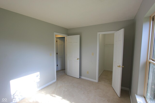 12221 Tallowtree Ct, Indianapolis, IN 46236 - unfurnished bedroom featuring a walk in closet, light colored carpet, and a closet