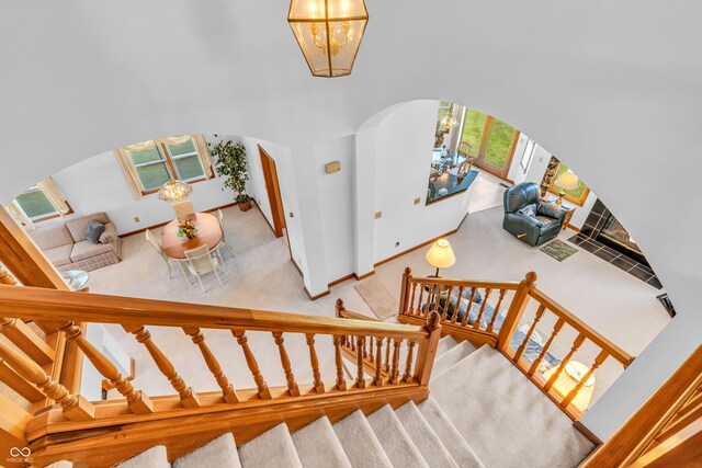 3244 W Burning Tree Rd, Crawfordsville, IN 47933 - stairway with arched walkways, a chandelier, and carpet floors