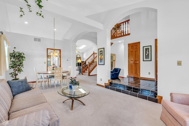 3244 W Burning Tree Rd, Crawfordsville, IN 47933 - living area featuring stairs, a chandelier, arched walkways, carpet floors, and a high ceiling