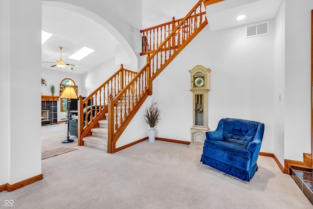 3244 W Burning Tree Rd, Crawfordsville, IN 47933 - staircase featuring carpet, a ceiling fan, arched walkways, and a fireplace