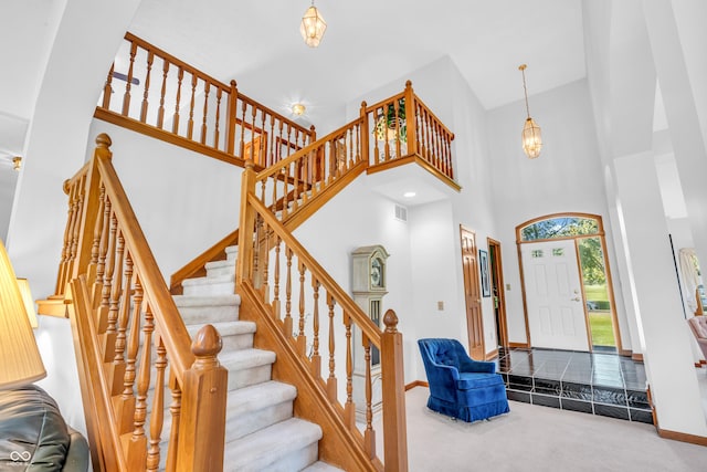 3244 W Burning Tree Rd, Crawfordsville, IN 47933 - carpeted foyer with a chandelier, a high ceiling, and stairs