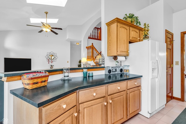 3244 W Burning Tree Rd, Crawfordsville, IN 47933 - kitchen with a skylight, white refrigerator with ice dispenser, dark countertops, a peninsula, and ceiling fan