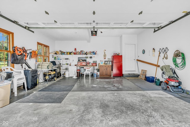 3244 W Burning Tree Rd, Crawfordsville, IN 47933 - garage featuring freestanding refrigerator, a garage door opener, and a workshop area