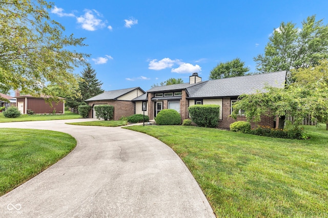 1006 Barry Dr, Lebanon, IN 46052 - view of front facade featuring brick siding, curved driveway, a front lawn, and a chimney