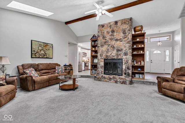1006 Barry Dr, Lebanon, IN 46052 - carpeted living room with beam ceiling, a stone fireplace, high vaulted ceiling, a ceiling fan, and a skylight