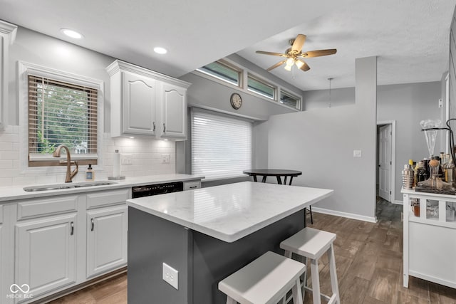 1006 Barry Dr, Lebanon, IN 46052 - kitchen featuring a breakfast bar area, tasteful backsplash, ceiling fan, white cabinetry, and dark wood finished floors