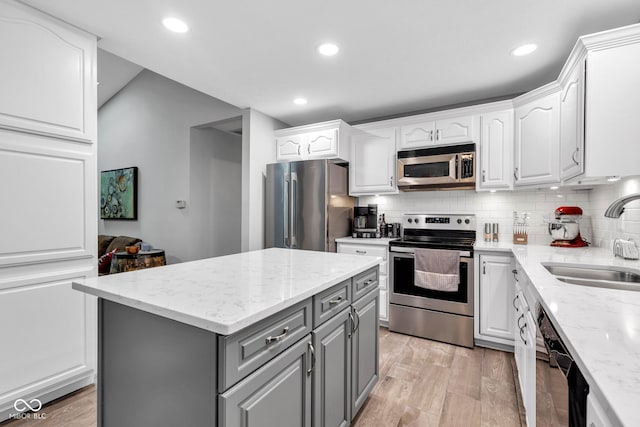 1006 Barry Dr, Lebanon, IN 46052 - kitchen with stainless steel appliances, gray cabinetry, white cabinets, a kitchen island, and tasteful backsplash