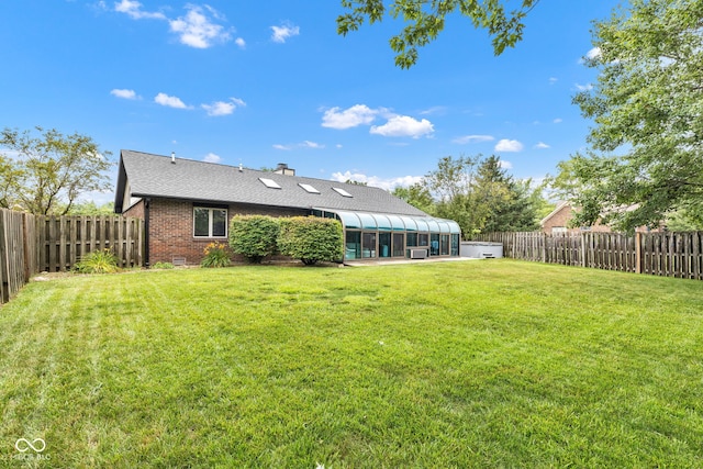 1006 Barry Dr, Lebanon, IN 46052 - back of house with a sunroom, brick siding, a fenced backyard, a chimney, and a shingled roof