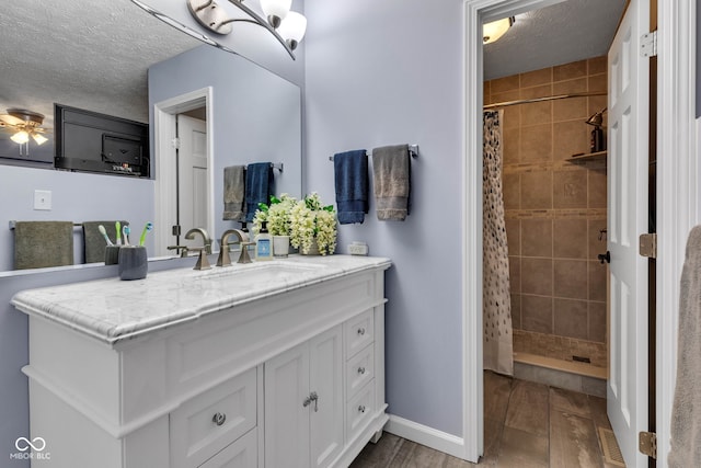 1006 Barry Dr, Lebanon, IN 46052 - full bathroom featuring a textured ceiling, vanity, a tile shower, and wood finished floors