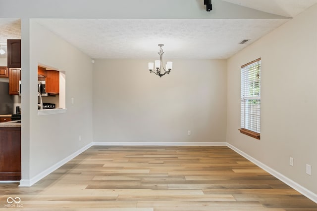 14098 Mimosa Ct, Fishers, IN 46038 - unfurnished dining area featuring light wood-type flooring, a chandelier, and a textured ceiling