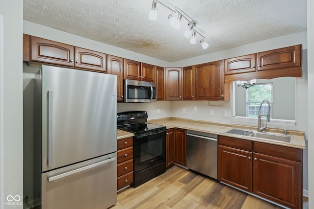 14098 Mimosa Ct, Fishers, IN 46038 - kitchen with stainless steel appliances, a textured ceiling, light wood-style flooring, and light countertops