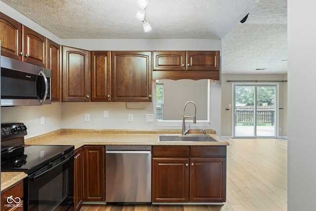 14098 Mimosa Ct, Fishers, IN 46038 - kitchen with appliances with stainless steel finishes, a textured ceiling, light countertops, light wood-type flooring, and track lighting