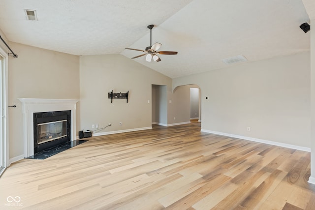14098 Mimosa Ct, Fishers, IN 46038 - unfurnished living room featuring a ceiling fan, light wood finished floors, arched walkways, lofted ceiling, and a premium fireplace
