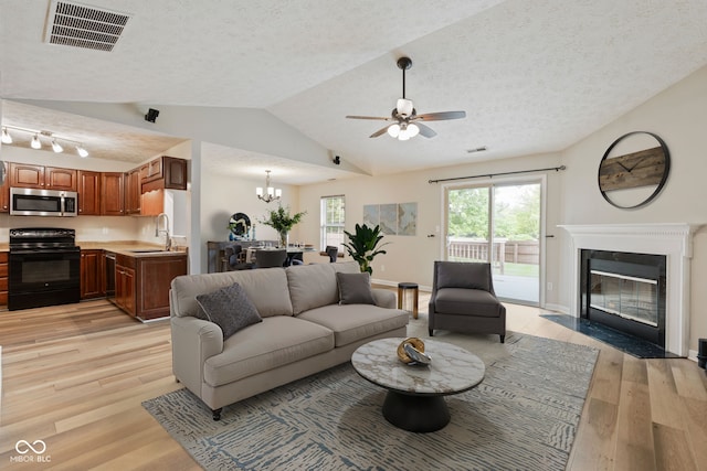 14098 Mimosa Ct, Fishers, IN 46038 - living area featuring a ceiling fan, light wood-style flooring, a fireplace with flush hearth, a textured ceiling, and lofted ceiling