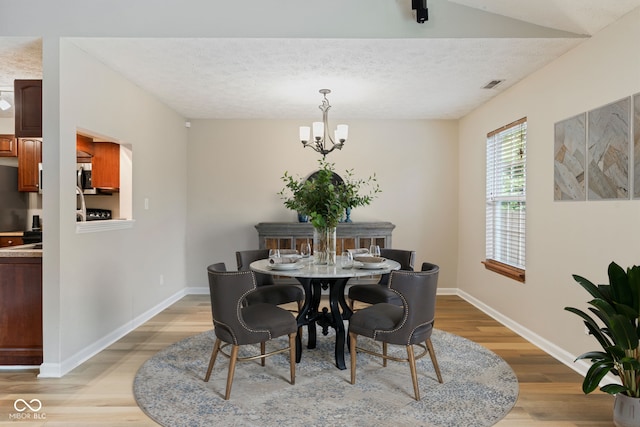 14098 Mimosa Ct, Fishers, IN 46038 - dining space with light wood finished floors, a chandelier, and a textured ceiling