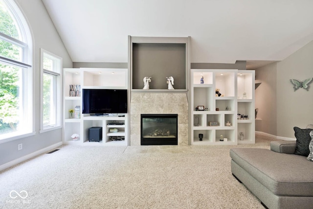7844 N Timber Run Ct, Indianapolis, IN 46256 - living area featuring a tile fireplace, healthy amount of natural light, carpet flooring, and vaulted ceiling