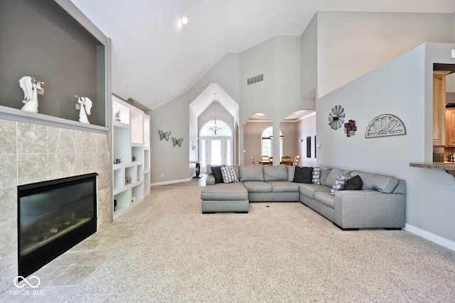 7844 N Timber Run Ct, Indianapolis, IN 46256 - carpeted living area with high vaulted ceiling, arched walkways, a tile fireplace, and built in shelves