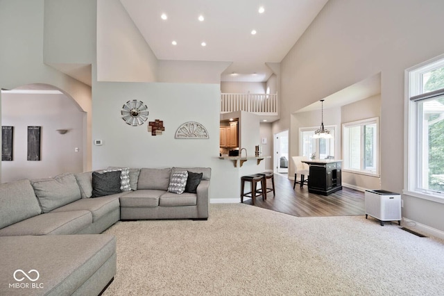 7844 N Timber Run Ct, Indianapolis, IN 46256 - living room featuring dark carpet, a high ceiling, arched walkways, recessed lighting, and a chandelier