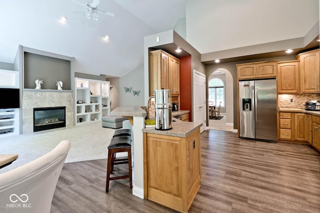 7844 N Timber Run Ct, Indianapolis, IN 46256 - kitchen featuring stainless steel fridge with ice dispenser, arched walkways, a breakfast bar, wood finished floors, and ceiling fan