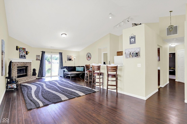 6417 Meadowpond Way, Indianapolis, IN 46235 - living area featuring vaulted ceiling, wood finished floors, a brick fireplace, and rail lighting