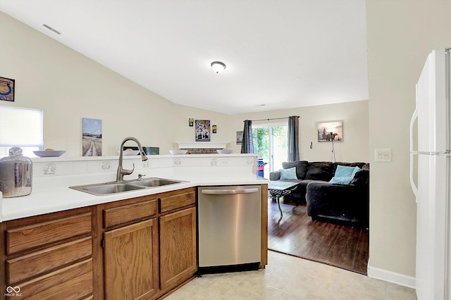 6417 Meadowpond Way, Indianapolis, IN 46235 - kitchen with stainless steel dishwasher, freestanding refrigerator, brown cabinets, open floor plan, and vaulted ceiling