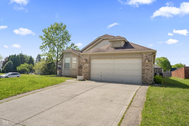 6933 Lohr Way, Indianapolis, IN 46214 - view of front facade featuring brick siding, driveway, and an attached garage