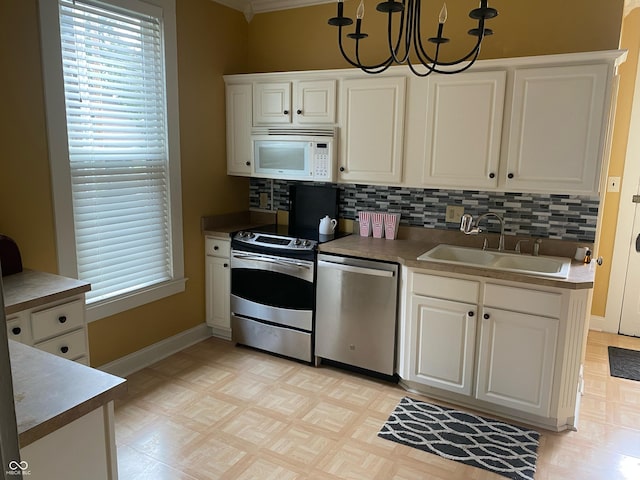 1402 SE 1st St, Evansville, IN 47713 - kitchen featuring appliances with stainless steel finishes, white cabinets, tasteful backsplash, and healthy amount of natural light