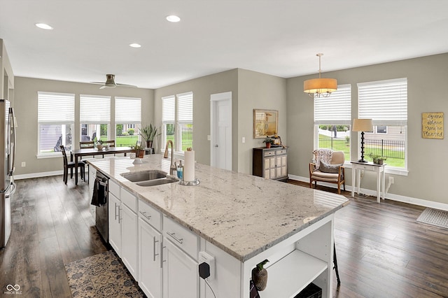 10490 Cleary Trace Dr, Fishers, IN 46040 - kitchen featuring stainless steel appliances, white cabinetry, light stone counters, dark wood-style floors, and an island with sink