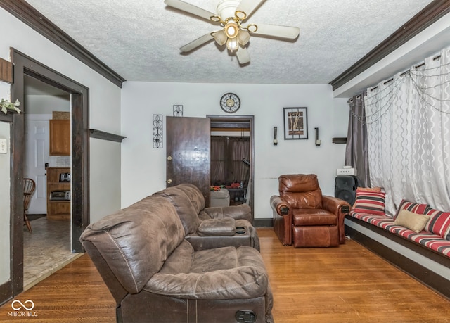 21 N Tremont St, Indianapolis, IN 46222 - living room featuring a textured ceiling, a ceiling fan, wood finished floors, and ornamental molding