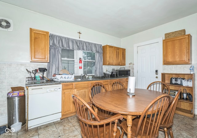21 N Tremont St, Indianapolis, IN 46222 - kitchen with dishwasher, dark countertops, stainless steel microwave, tasteful backsplash, and tile walls