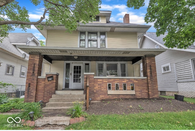 21 N Tremont St, Indianapolis, IN 46222 - traditional style home featuring a chimney, covered porch, and brick siding