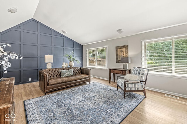 11329 Moss Dr, Carmel, IN 46033 - living room featuring vaulted ceiling, a decorative wall, and light wood finished floors
