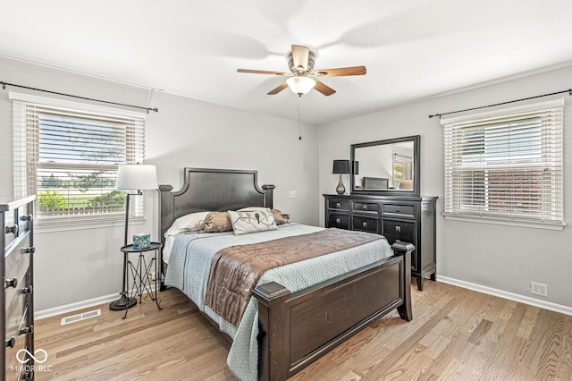 11329 Moss Dr, Carmel, IN 46033 - bedroom featuring multiple windows, light wood-style floors, and a ceiling fan