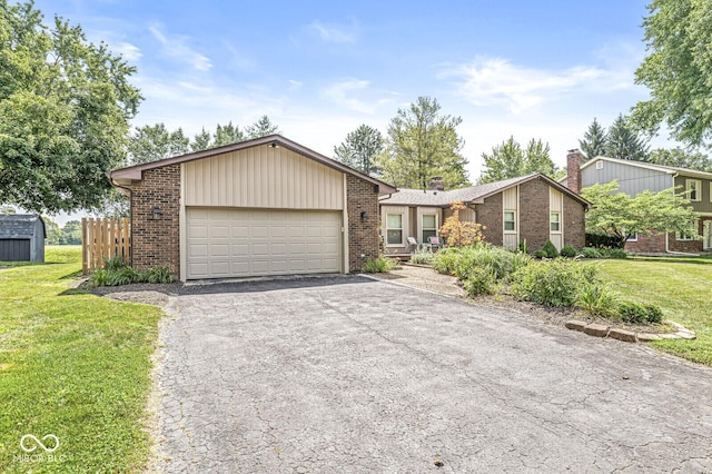 11329 Moss Dr, Carmel, IN 46033 - mid-century modern home featuring an attached garage, brick siding, asphalt driveway, and a front yard