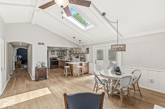 11329 Moss Dr, Carmel, IN 46033 - dining space featuring beam ceiling, ceiling fan, a skylight, light wood-type flooring, and high vaulted ceiling