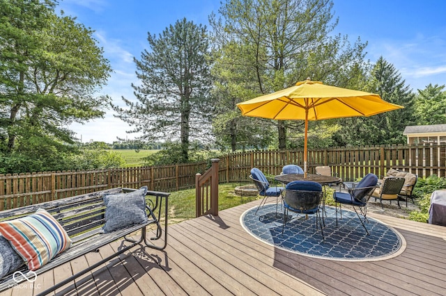 11329 Moss Dr, Carmel, IN 46033 - deck featuring a fenced backyard, a fire pit, outdoor dining area, and view of scattered trees