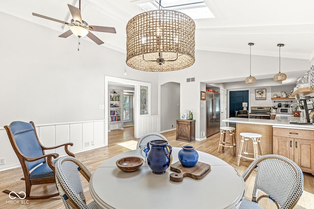 11329 Moss Dr, Carmel, IN 46033 - dining space featuring light wood-style flooring, lofted ceiling, arched walkways, and a ceiling fan