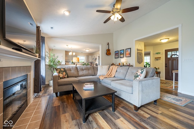 12854 Longleaf Ln, Fishers, IN 46038 - living room featuring vaulted ceiling, a tiled fireplace, wood finished floors, and ceiling fan