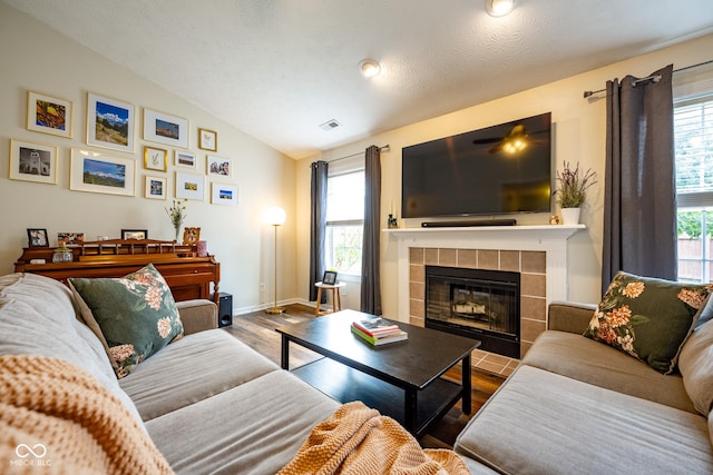 12854 Longleaf Ln, Fishers, IN 46038 - living area featuring lofted ceiling, a tile fireplace, and wood finished floors