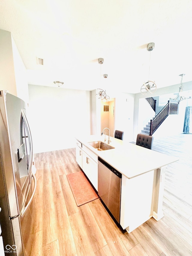 4732 Bethel Creek Blvd, Indianapolis, IN 46239 - kitchen with stainless steel appliances, a chandelier, light wood-style floors, and white cabinets