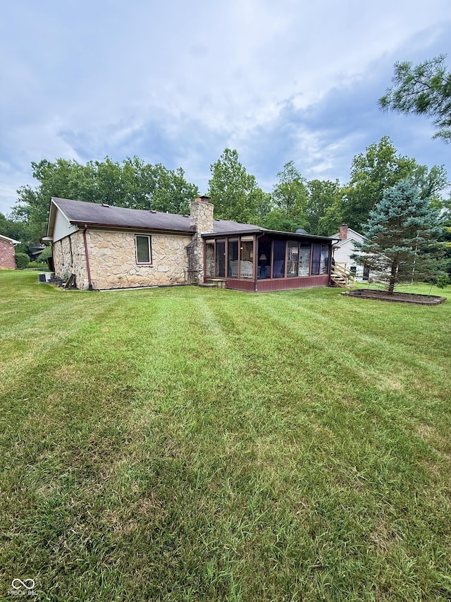 511 Canterbury Ct, Noblesville, IN 46060 - back of property featuring a sunroom, stone siding, and a lawn