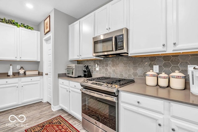 9470 Tobin Cir, Avon, IN 46123 - kitchen featuring stainless steel appliances, white cabinetry, and tasteful backsplash