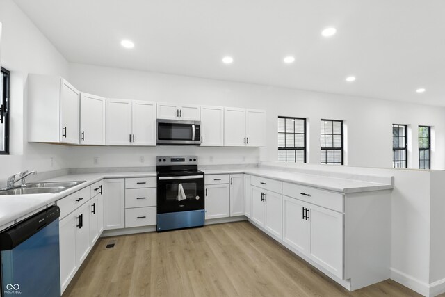 3455 N Illinois St, Indianapolis, IN 46208 - kitchen with stainless steel appliances, light wood finished floors, light countertops, white cabinets, and recessed lighting
