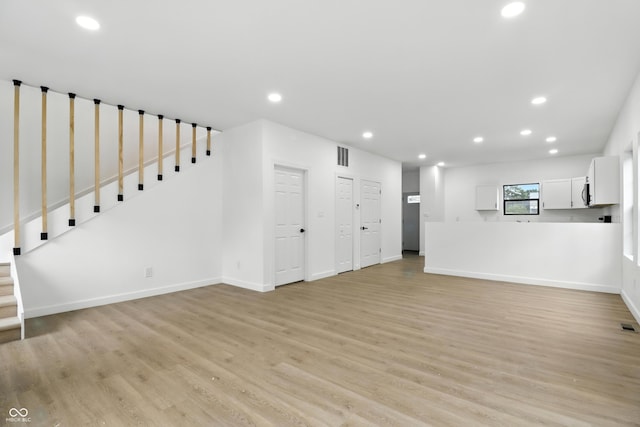 3455 N Illinois St, Indianapolis, IN 46208 - unfurnished living room with recessed lighting, light wood finished floors, and stairway