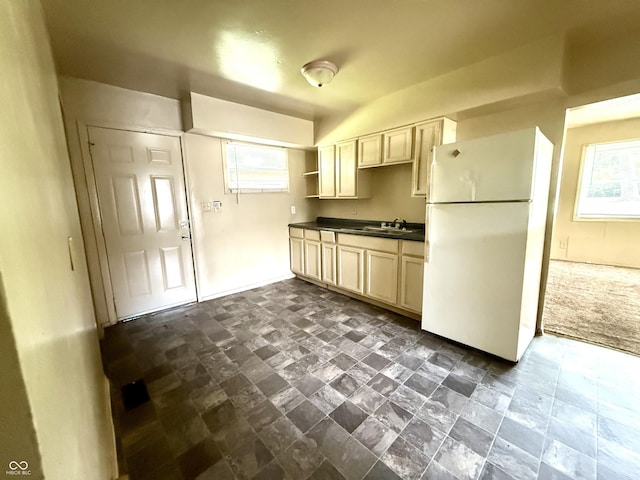 3034 E 35th St, Indianapolis, IN 46218 - kitchen with freestanding refrigerator, dark countertops, plenty of natural light, and dark stone finish floors