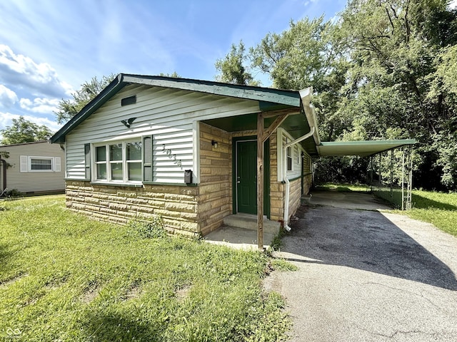 3034 E 35th St, Indianapolis, IN 46218 - view of front of property with asphalt driveway, a front lawn, stone siding, a carport, and entry steps