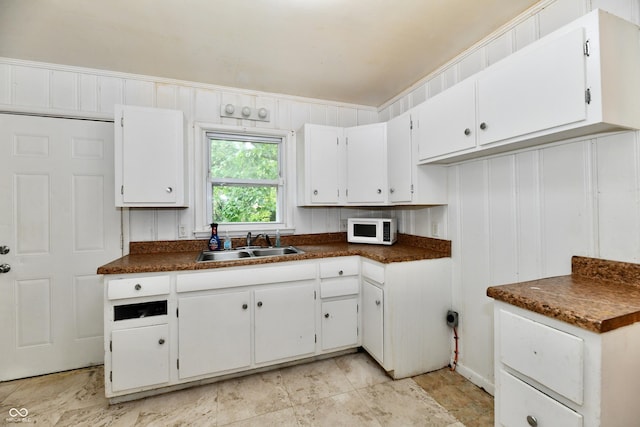 8921 E 21st St, Indianapolis, IN 46219 - kitchen with white microwave, dark countertops, and white cabinetry