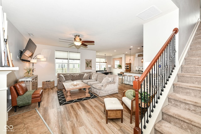 6819 Park Grove Blvd, Whitestown, IN 46075 - living room featuring a ceiling fan, stairway, and light wood-style flooring