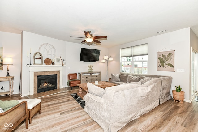 6819 Park Grove Blvd, Whitestown, IN 46075 - living area with a ceiling fan, a tiled fireplace, and light wood finished floors